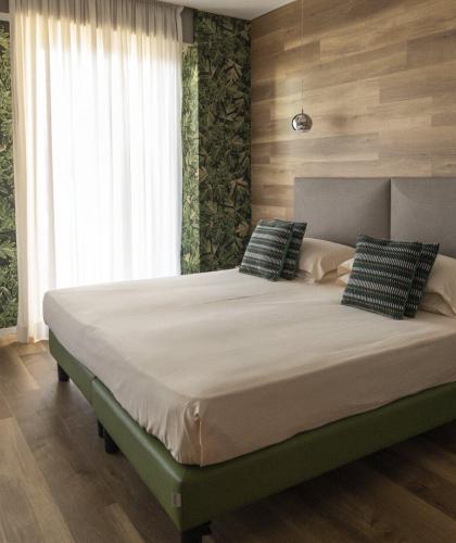 Camera elegante con letto accogliente e pareti decorate, atmosfera rilassante e naturale.