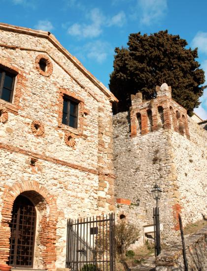 Antico castello di pietra sotto un cielo azzurro, evocando storia e mistero.