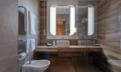 Bagno moderno con doppio lavabo, bidet e doccia in vetro.