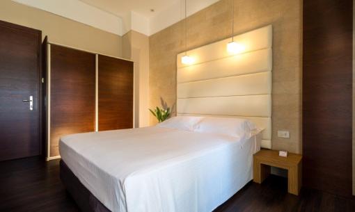 Modern room with double bed and soft lighting.