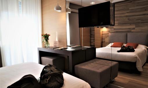 Chambre moderne avec lit double, TV et décor élégant.