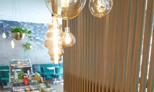Buffet con croissant, torte e altri dolci in un ambiente moderno e luminoso.