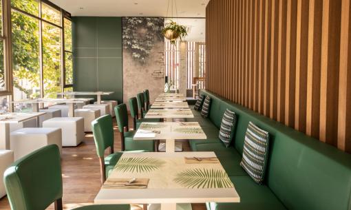 Ristorante moderno con arredi verdi e decorazioni naturali.
