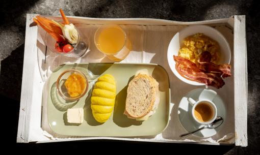 Colazione con uova, pancetta, pane e succo d'arancia.