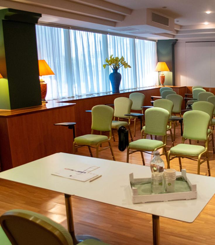 Conference room with green chairs and warm lighting.